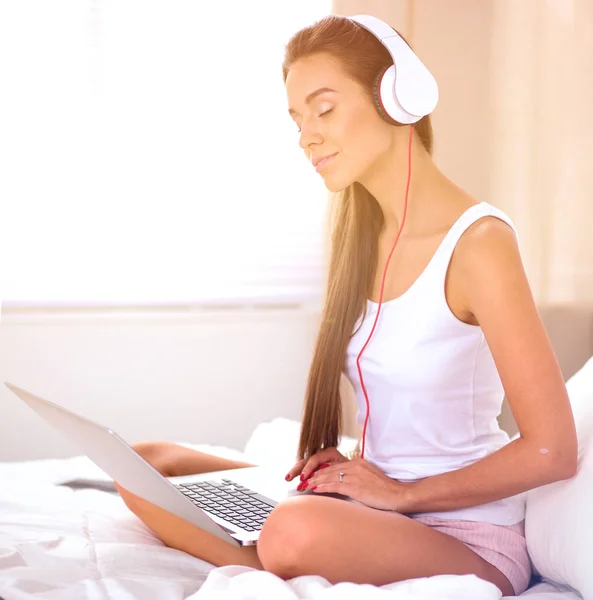 Młoda piękna kobieta w łóżku słuchając muzyki — Zdjęcie stockowe