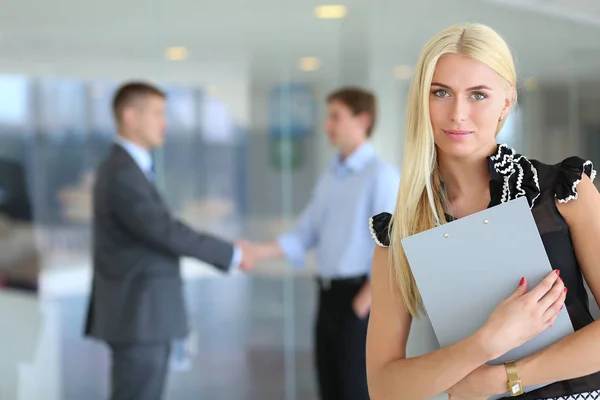 Portret van jonge zakenvrouw in functie met collega 's op de achtergrond . — Stockfoto