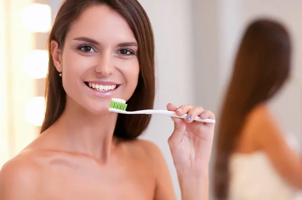 Portrait of a young girl cleaning her teeth — Stock Photo, Image