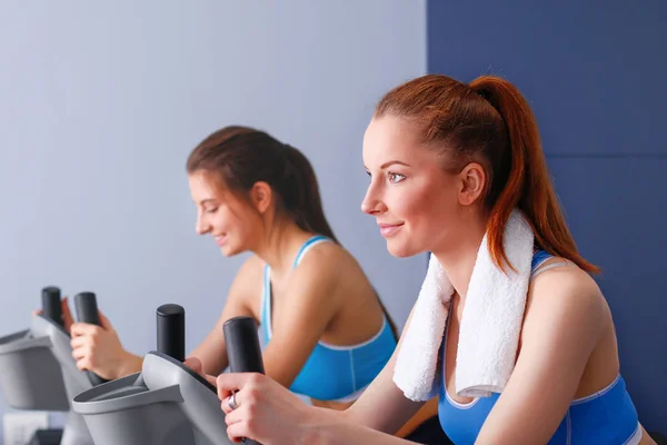 Grupo de personas en el gimnasio haciendo ejercicio en entrenadores cruzados. Gente en el gimnasio — Foto de Stock