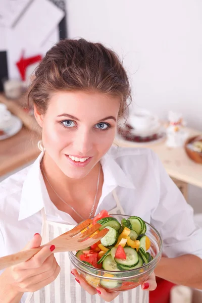 Usměvavá mladá žena připravuje salát v kuchyni. — Stock fotografie