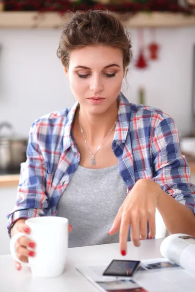 Lachende vrouw met haar mobiel in de keuken. Lachende vrouw. — Stockfoto