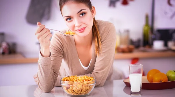 Усміхнена приваблива жінка снідає в інтер'єрі кухні — стокове фото