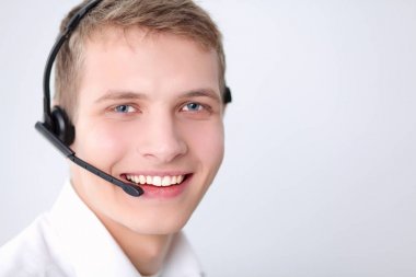 Gri arka plan üzerinde oturan gülümseyen genç adam portresi. Genç adam portresi