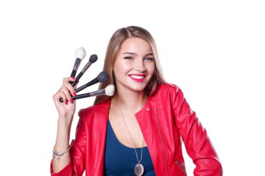 Genç ve güzel bir kadın bir elinde makyaj için boya ve gölgeli bir palet, makyaj için ikinci el fırça..