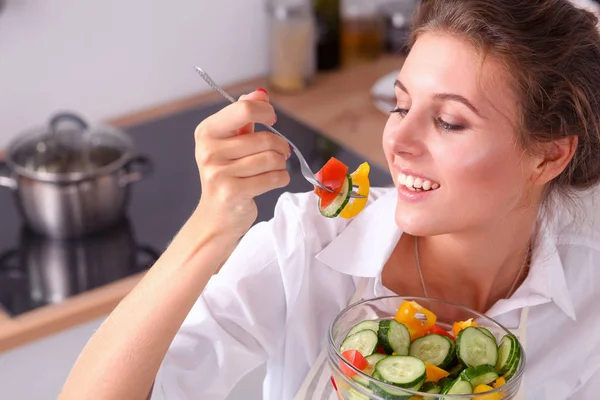 Smiling young woman preparing salad in the kitchen. — Stock Photo, Image