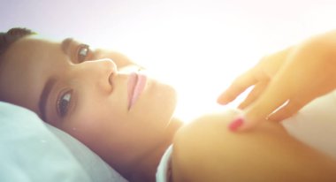 Evde yatakta yatan genç güzel kadın