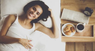 Evde yatakta yatan genç güzel kadın