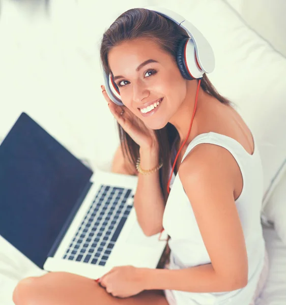 Young beautiful woman in bed listening to music — Stock Photo, Image
