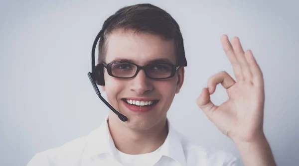 Pracovník služeb pro zákazníky ukazující ok, izolovaných na bílém pozadí — Stock fotografie