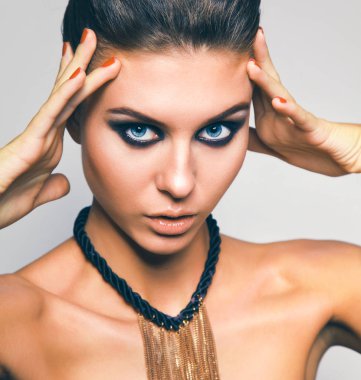 Gri arka plan üzerinde duran güzel genç kadın