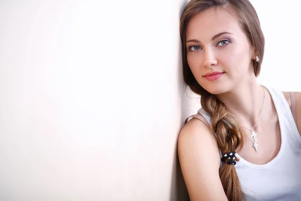 Young woman sitting on the floor near wall . Young woman — Stock Photo, Image