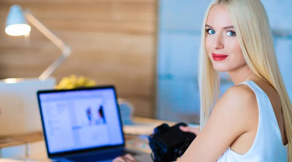 Fashion designers working in studio sitting on the desk — Stock Photo, Image