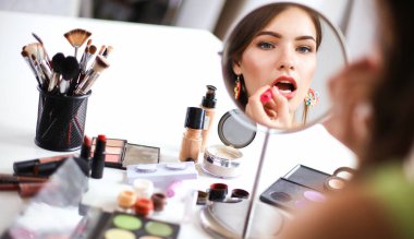 Genç güzel kadın ayna, Masa başında oturan yakınındaki makyaj yapma