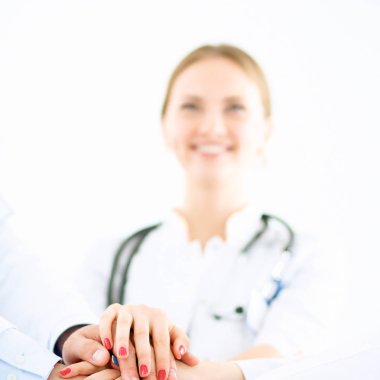 Doktorlar ve hemşireler tıbbi bir ekipte el ele tutuşuyorlar. 