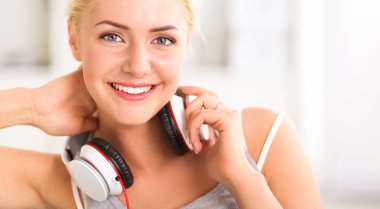 Evdeki genç ve güzel kadın kanepede oturup müzik dinliyor.
