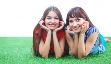 İki genç kadın yeşil çim üzerinde yalan 