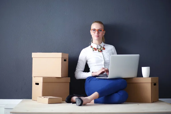 Mujer sentada en el suelo cerca de una caja con portátil. Empresaria —  Fotos de Stock