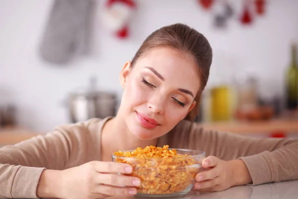 Smiling attractive woman having breakfast in kitchen interior. Smiling attractive woman.