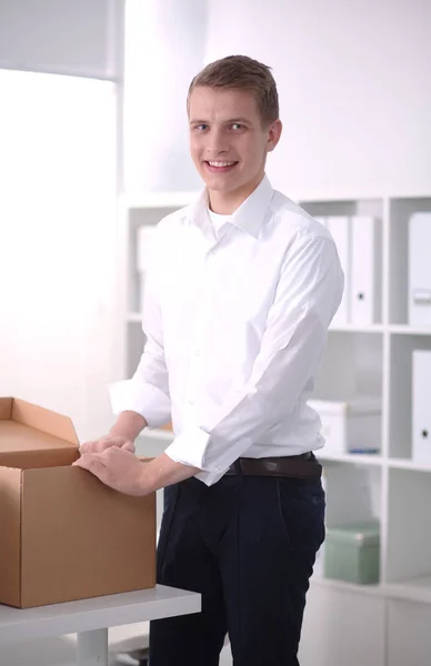 Portret van de jonge man die lacht zittend op een grijze achtergrond. Portret van jonge man — Stockfoto