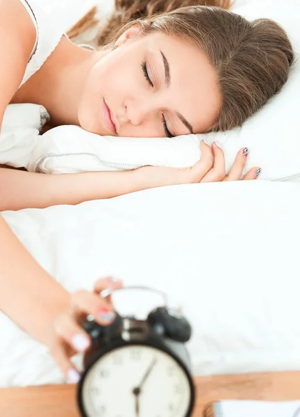 Una giovane donna che disattiva la sveglia la mattina — Foto Stock