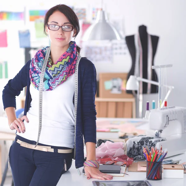 Designer de moda bonita de pé perto da mesa em estúdio — Fotografia de Stock