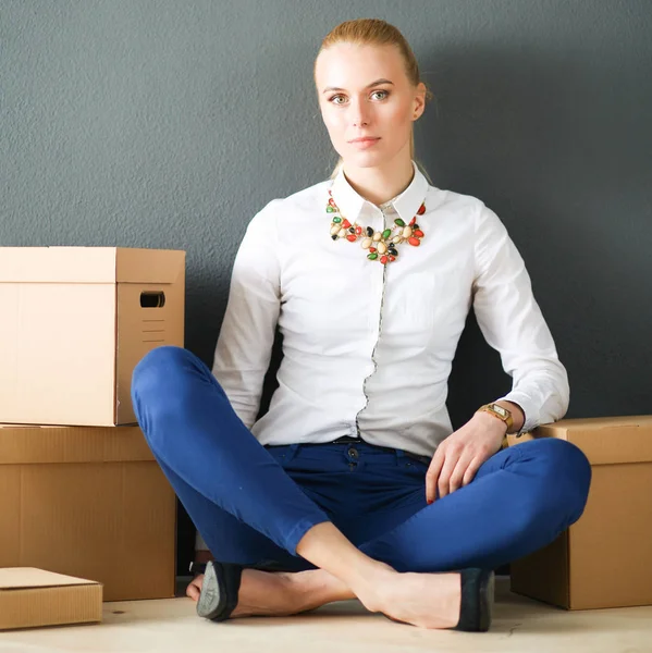 Donna seduta sul pavimento vicino a una scatola con computer portatile — Foto Stock