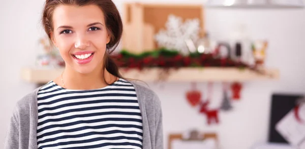 Smiling young woman standing in the kitchen — Stock Photo, Image