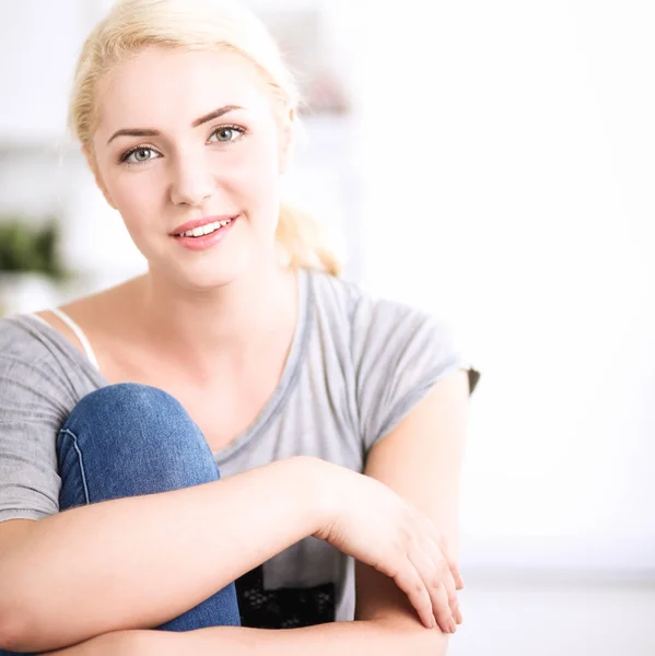 Ung vacker kvinna sitter på soffan på sitt rum — Stockfoto