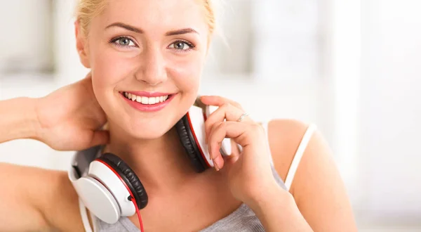 Young beautiful woman at home sitting on sofa and listening music — Stock Photo, Image