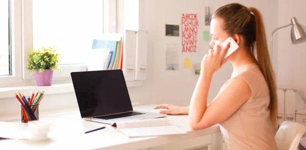Giovane donna d'affari seduta alla scrivania e che parla al telefono — Foto Stock