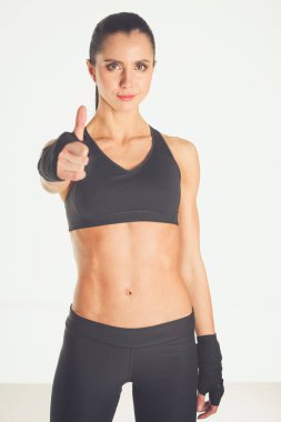 Mutlu bir fitness kadınının portresi tamam işareti gösteriyor.