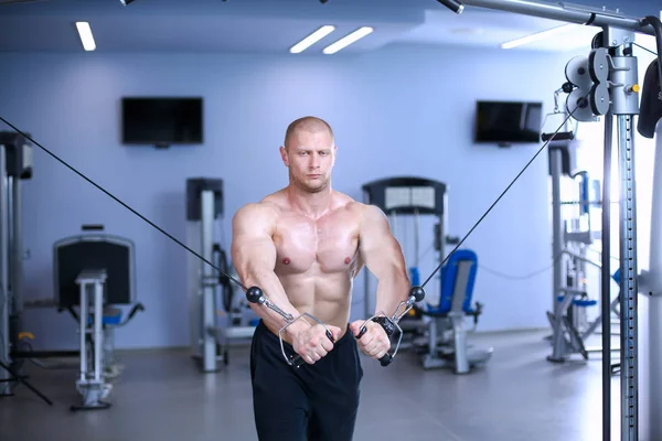 Der junge Mann trainiert im Fitnessstudio mit Übungen. junger Mann — Stockfoto