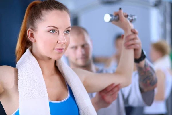 Hermosa mujer en el gimnasio haciendo ejercicio con su entrenador. Hermosa mujer. Gimnasio — Foto de Stock