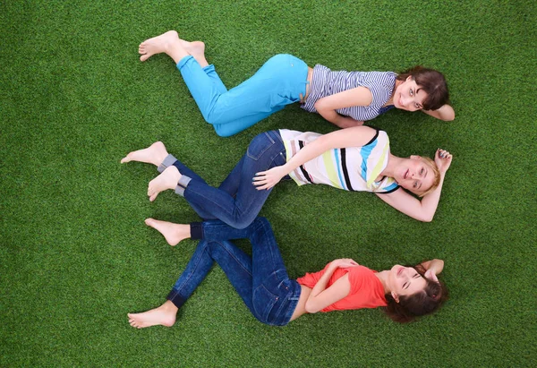 Junge Frauen auf grünem Gras liegen. junge Frauen — Stockfoto