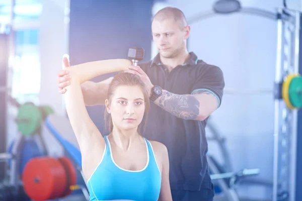 Schöne Frau im Fitnessstudio, die mit ihrem Trainer trainiert. schöne Frau. Fitnessstudio — Stockfoto