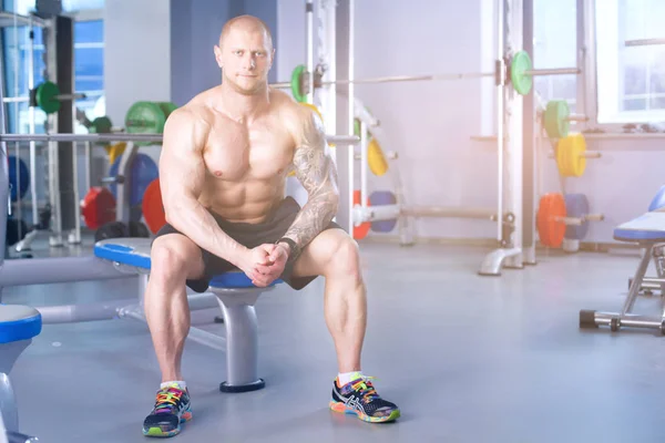 Der junge Mann trainiert im Fitnessstudio mit Übungen. junger Mann — Stockfoto