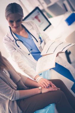 Doktor ve hasta masada otururken bir şey tartışıyorlar. Tıp ve sağlık hizmetleri kavramı. Doktor ve hasta.