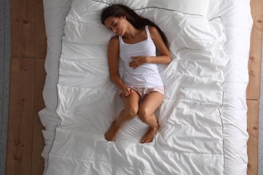 Genç ve güzel bir kadın yatakta yatıyor..