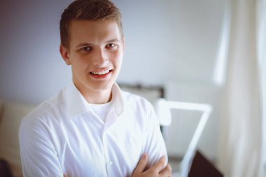 Genç iş adamı ayakta ofisinde çalışıyor. Genç iş adamı