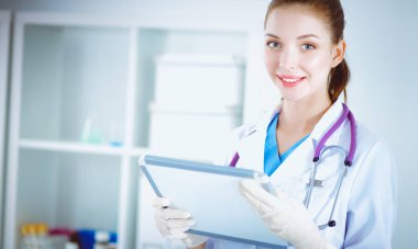 Kadın doktor hastanede dosyayla bekliyor.