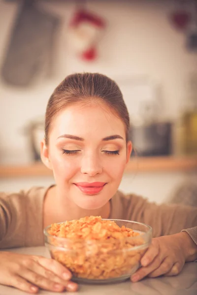 Smiling attractive woman having breakfast in kitchen interior. Smiling attractive woman.