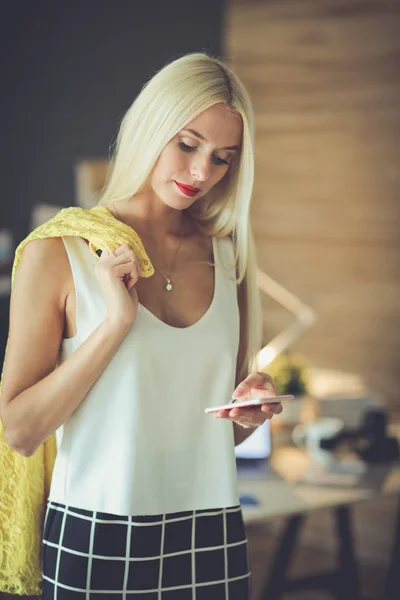 Jovem empresária sentada na mesa com copo — Fotografia de Stock