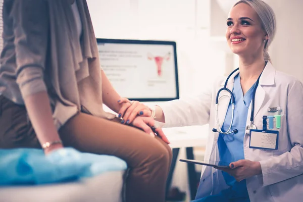 Dokter en patiënt bespreken iets terwijl ze aan tafel zitten. Geneeskunde en gezondheidszorg. Dokter en patiënt — Stockfoto