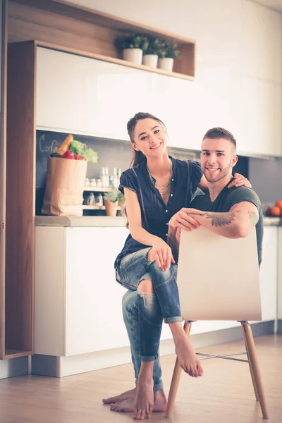 Belo jovem casal está se divertindo na cozinha em casa — Fotografia de Stock