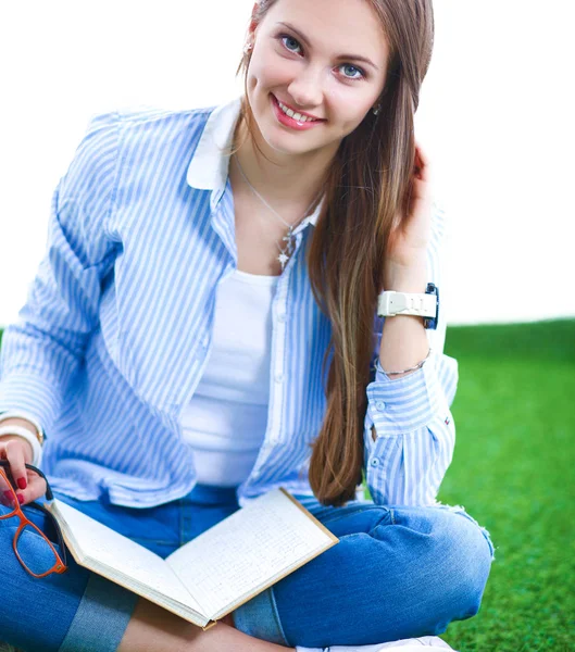 Jonge vrouw zitten met boek op gras — Stockfoto