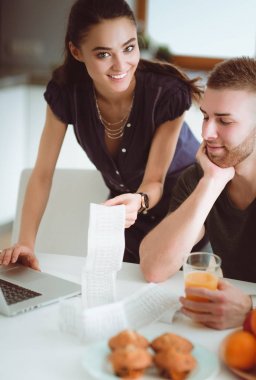 Çift evde mutfak içinde laptop ile onların fatura ödeme