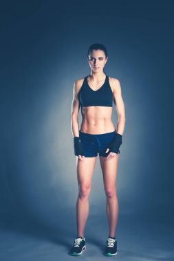 Spor giyim siyah arka plan karşı poz kas genç kadın.