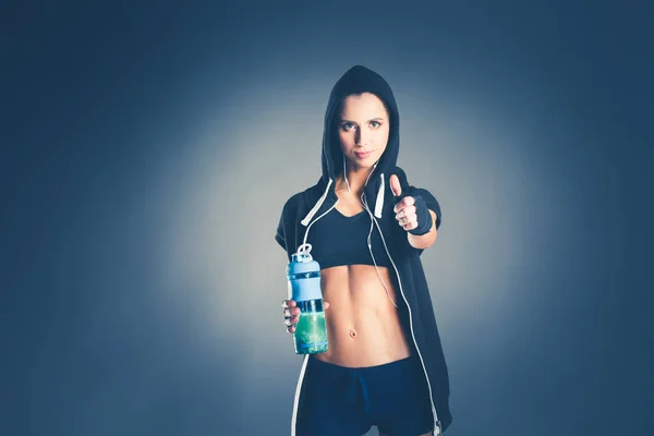 Девушка с бутылкой в руках после спорта. — стоковое фото