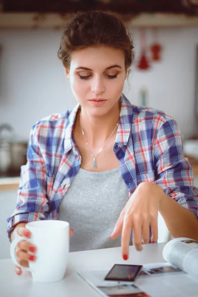 Lachende vrouw met haar mobiel in de keuken. Lachende vrouw. — Stockfoto